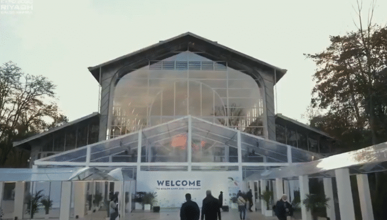Modern glass entrance at the Expo 2030 registration symposium in Paris reflecting Saudi design identity