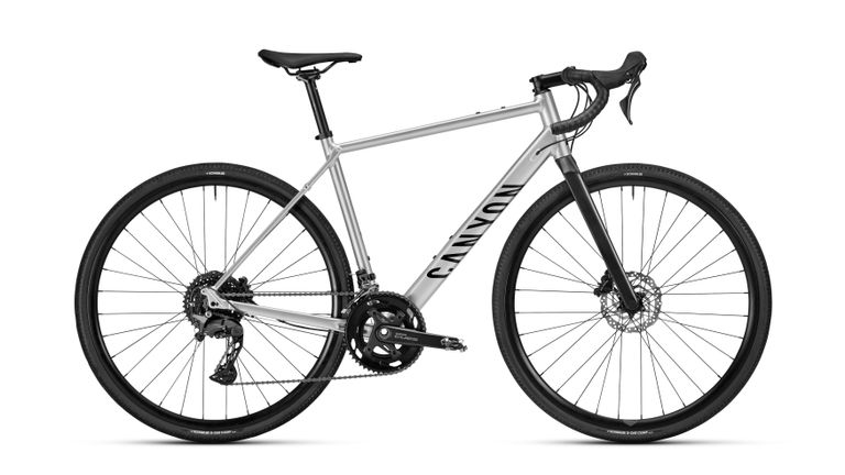 A sleek Canyon Endurance: AllRoad bike with a silver frame, showcasing its versatile design against a white background.