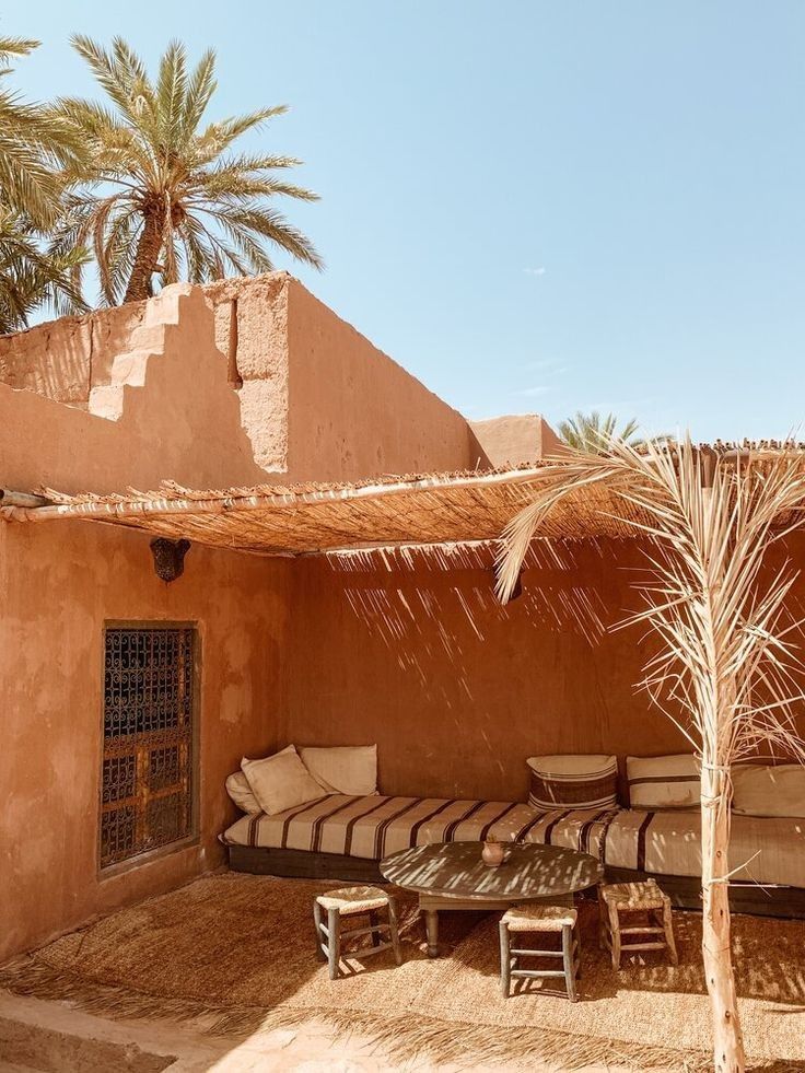 A traditional desert relaxation area featuring wooden furniture reflecting local heritage, with a thatched roof and small plants adding a touch of nature.