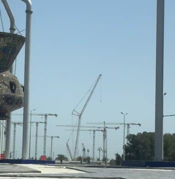 A construction site with massive cranes lifting building materials.
