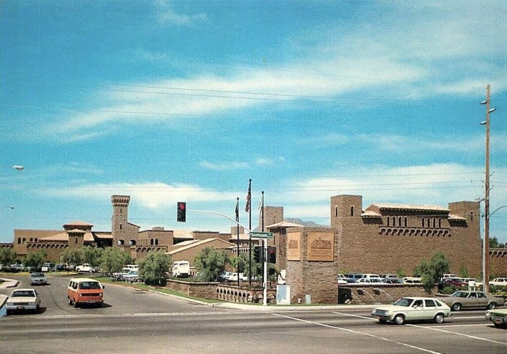 واجهة The Borgata في سكوتسديل، تُظهر تصميمًا معماريًا قويًا مع أبراج متعددة ونوافذ مزخرفة، تحت سماء صافية، وسط حركة مرور نشطة.