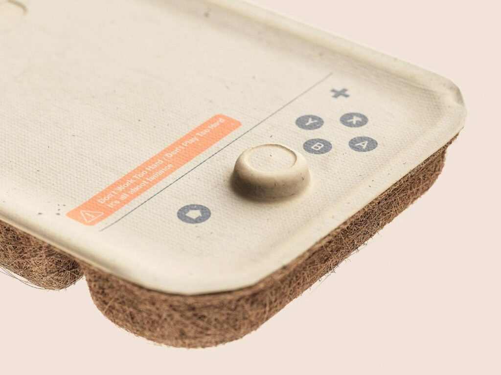 جزء من تصميم عبوة Nintendo Switch مصنوعة من ألياف جوز الهند، يحتوي على أزرار وعلامات توجيهية بيئية.