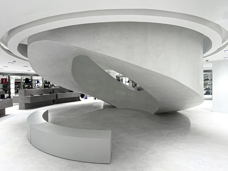 A contemporary art gallery with clean, minimalist aesthetics and an elegant curved white platform that highlights the artwork in a striking way.