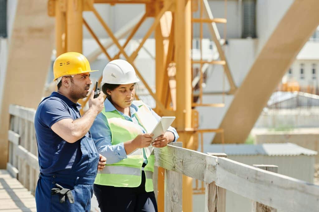 Engineers from Granite Construction discuss the details of executing an infrastructure project at a construction site in 2025, as part of coordination efforts and addressing operational challenges.