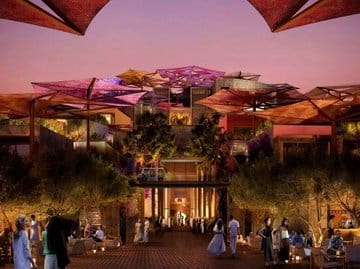 A nighttime view of a luxurious complex with multi-level buildings adorned with colorful canopy roofs. The area is bustling with guests enjoying a serene and cozy atmosphere under soft lighting and lush greenery.