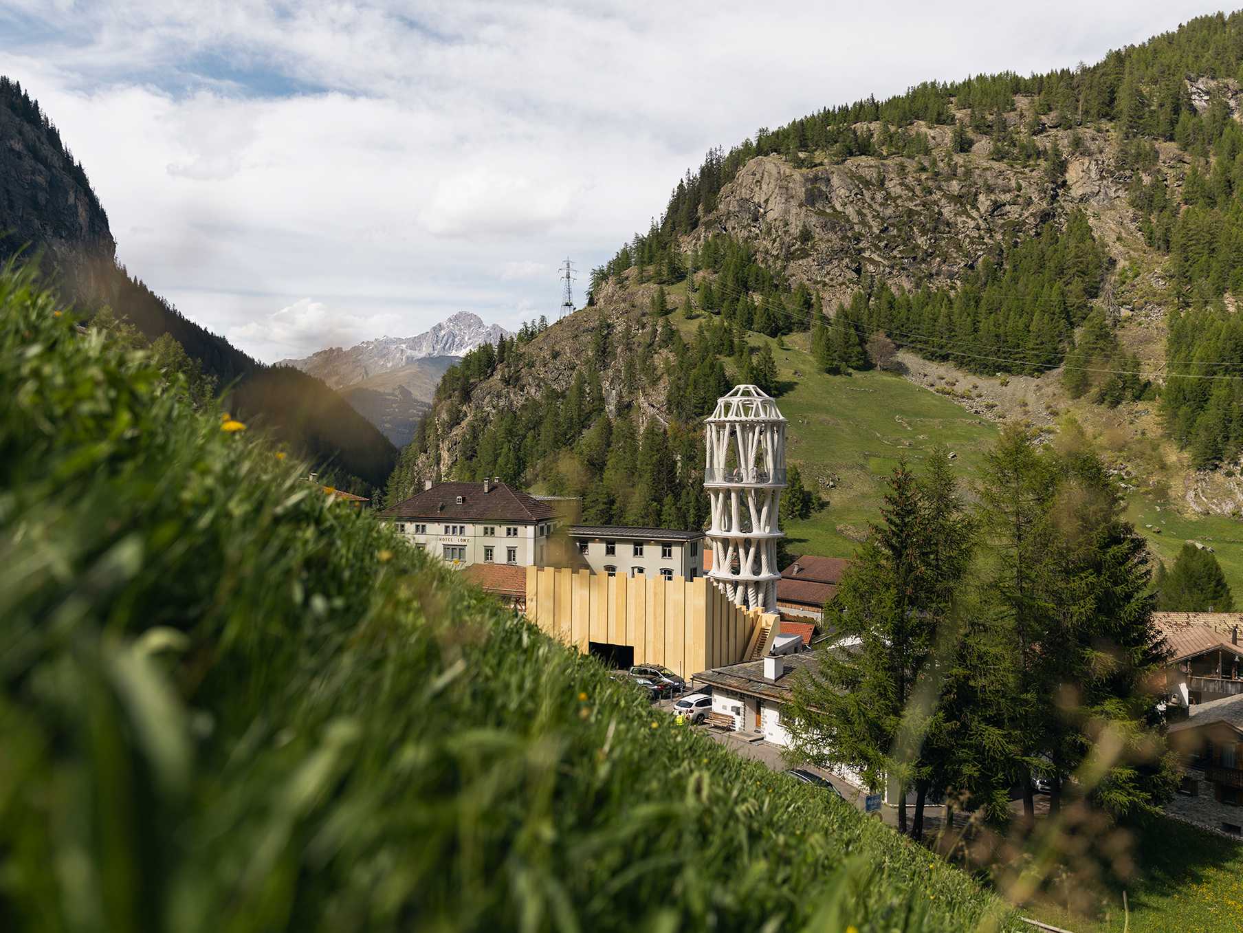 The 30-meter-tall 3D printed concrete tower stands visible from afar amid the trees.