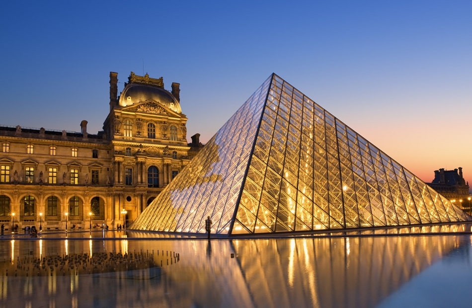Louvre Museum's illuminated glass pyramid at night in Paris