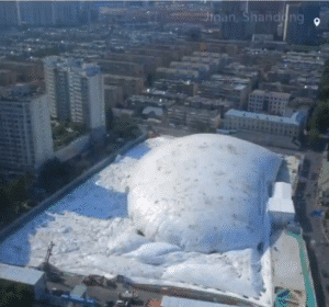 A massive inflatable dome fully covering a construction site in Jinan, China, as part of an effort to reduce noise and dust.