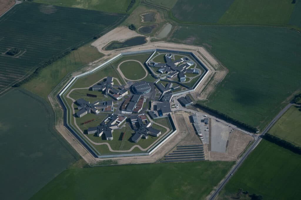 Aerial view of a Danish prison designed like a small town, with high security walls and an orderly internal layout.