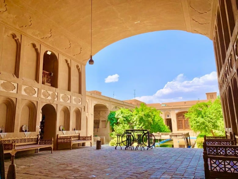 🇬🇧 A traditional courtyard in Yazd with a central pool and wooden windows, reflecting the local architectural style.