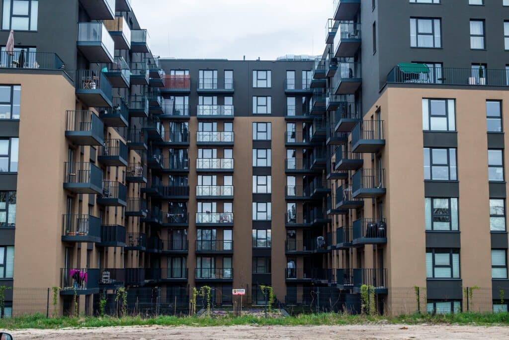 Facade of a multi-story residential building using varied materials like brick and concrete, in an urban setting.
