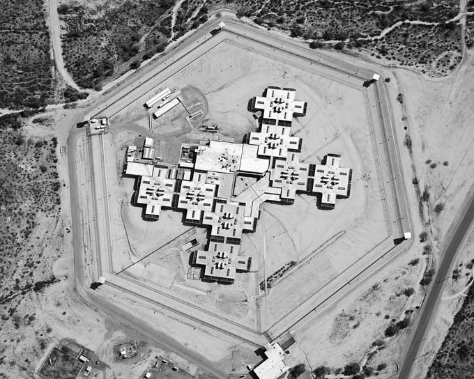 Overhead view of a high-security U.S. prison, showcasing rigid geometric zoning for control and surveillance.