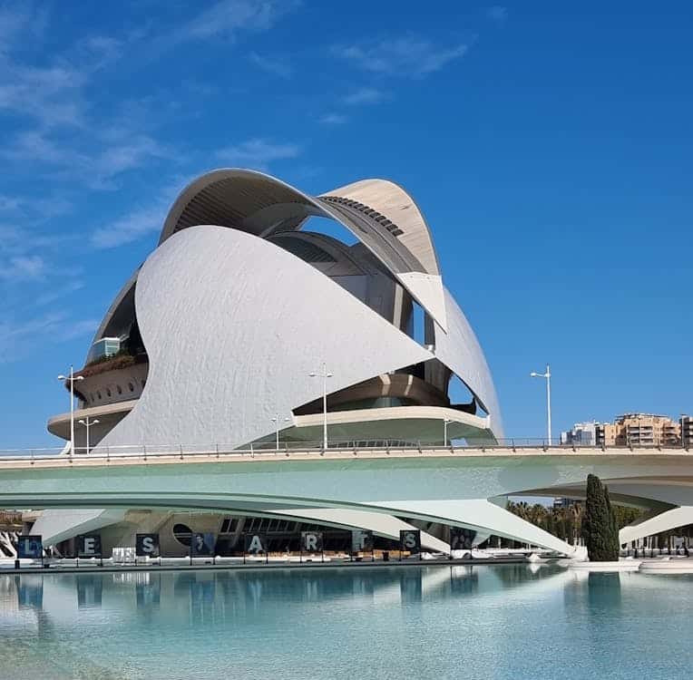 A modern white building with curved facades, reflecting a futuristic architectural style.