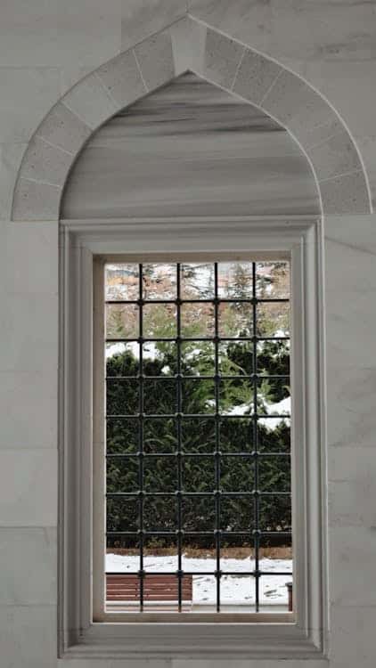 Elegant arched window overlooking a snowy garden