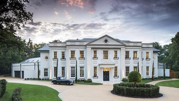 مدخل قصر أنيق بتصميم كلاسيكي وحديقة دائرية وممر للسيارات أمام المبنى