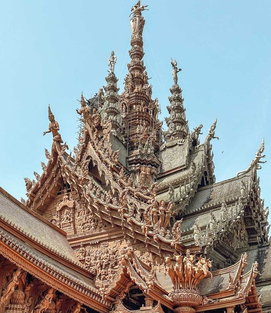 تفاصيل دقيقة من نقوش خشبية يدوية تزين واجهة معبد تايلاندي تقليدي.