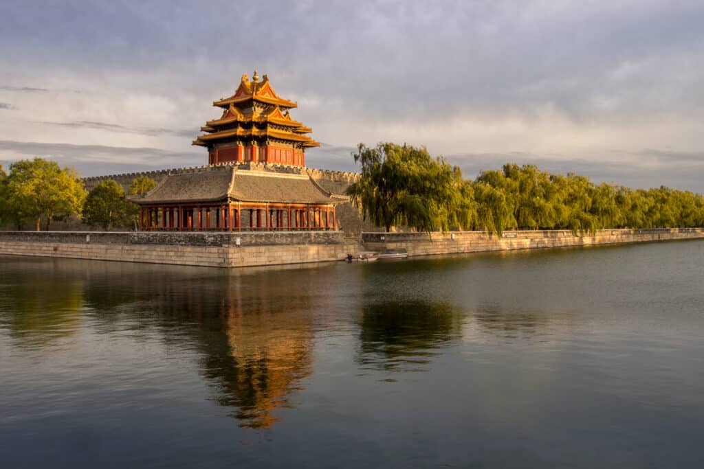 Close-up of a traditional Chinese gate within the Forbidden City, painted in imperial red and gold