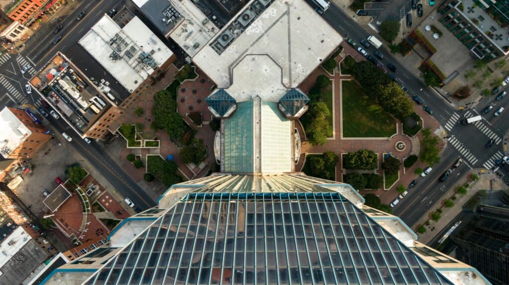 High-angle view of a modern skyscraper surrounded by green urban landscape