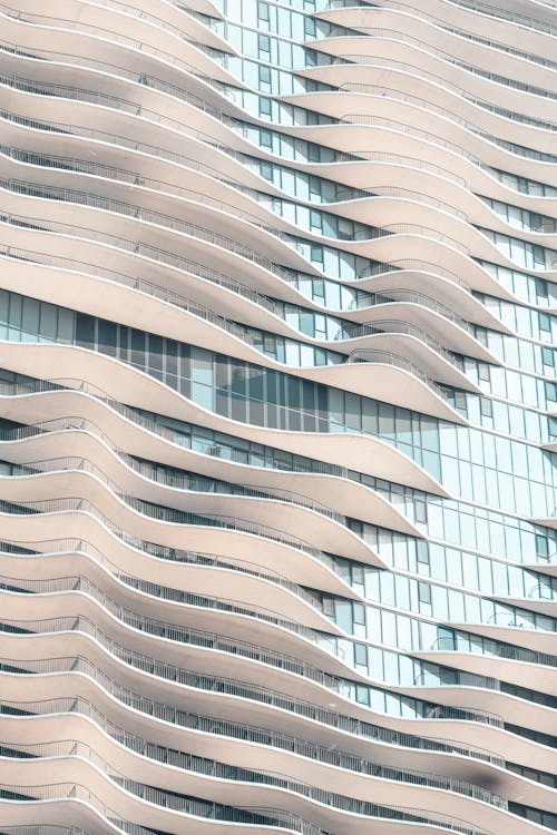 واجهة مبنى بتصميم متموج يشبه حركة الأمواج، يعكس الطراز المعاصر والابتكار التضاريسي.