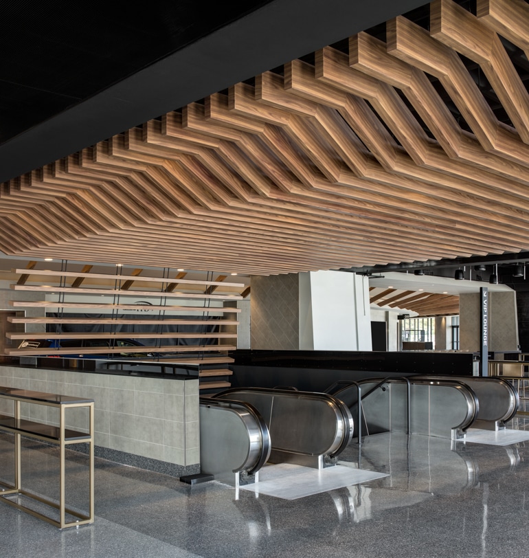 A modern office with an exposed wooden ceiling and integrated lighting.