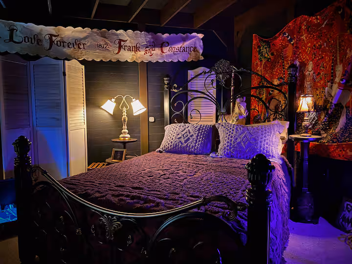 A dimly lit room with heavy curtains, reflecting a haunted and mysterious character.