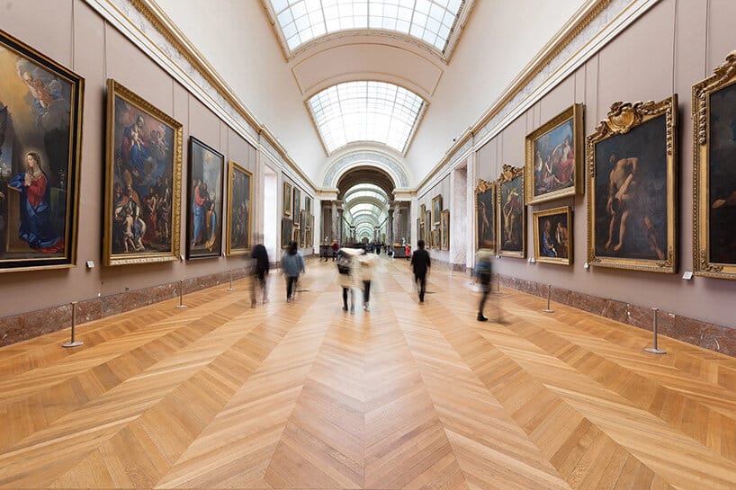 Interior gallery hallway at the Louvre showcasing classic artworks