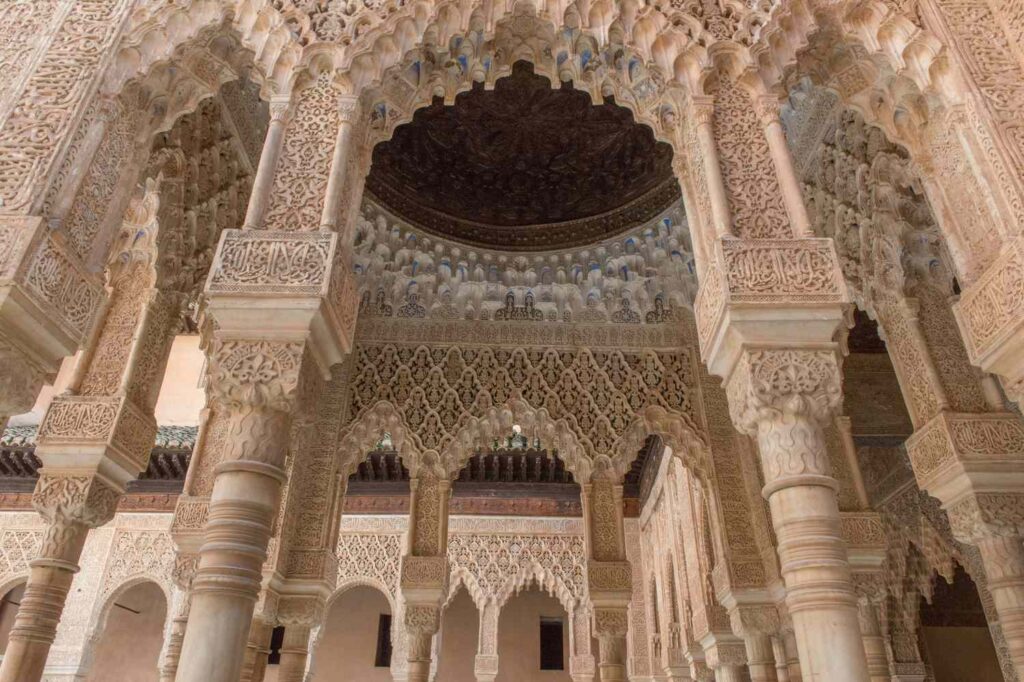 Columns and inner windows filtering natural light in one of Alhambra&rsquo;s wings