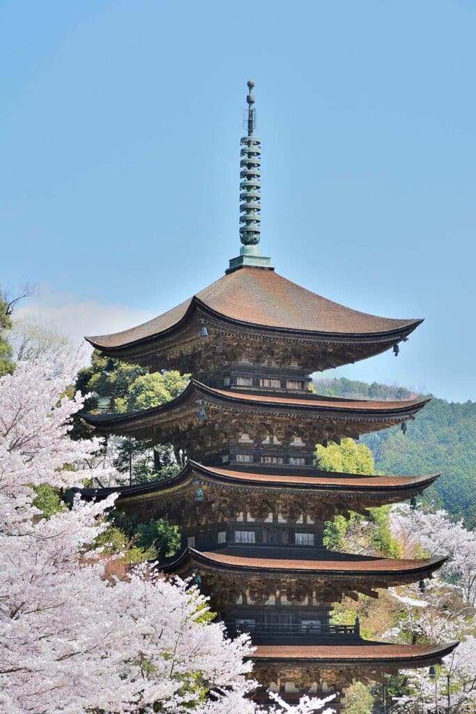Detailed view of wooden pillars and layered roofs in a Japanese pagoda