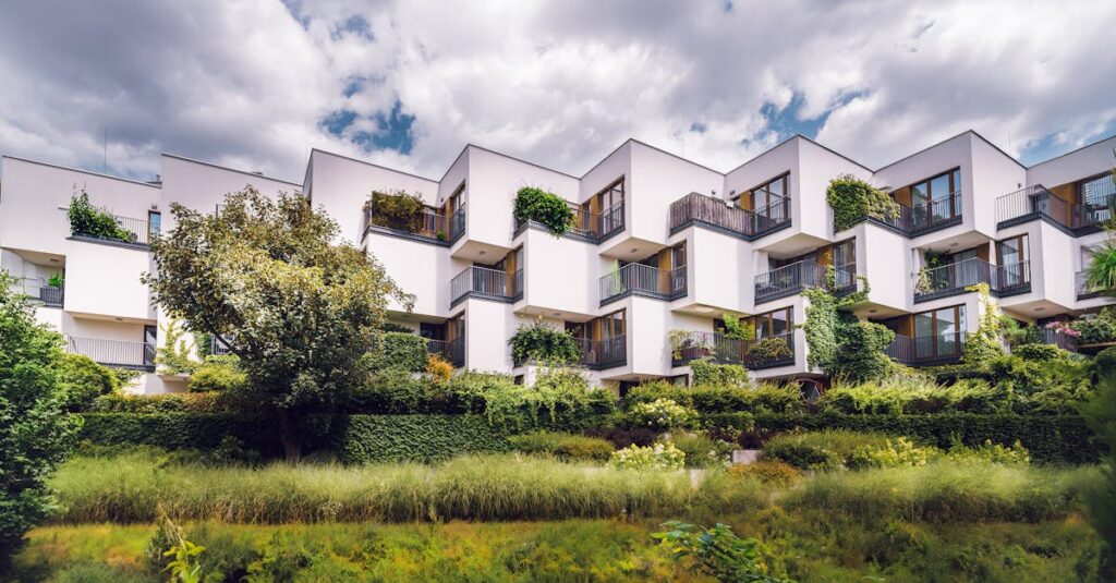 Contemporary housing complex with green plants covering its facade, reflecting sustainable architecture.