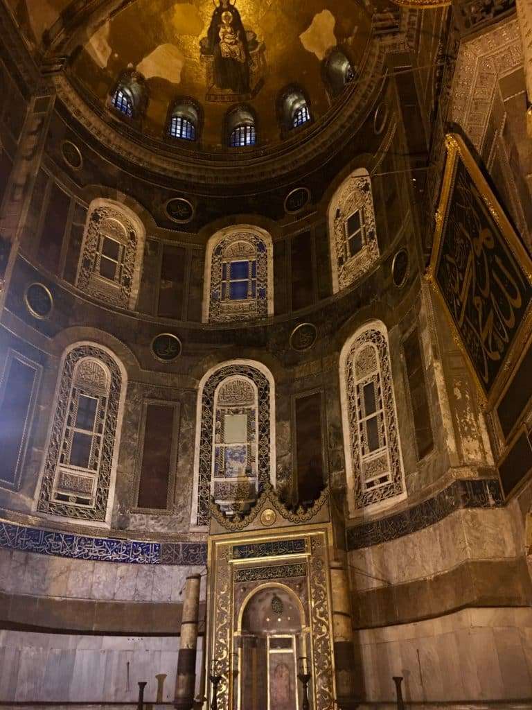 Wide interior shot of the grand prayer hall in Sultan Ahmed Mosque, highlighting domes and decorations.