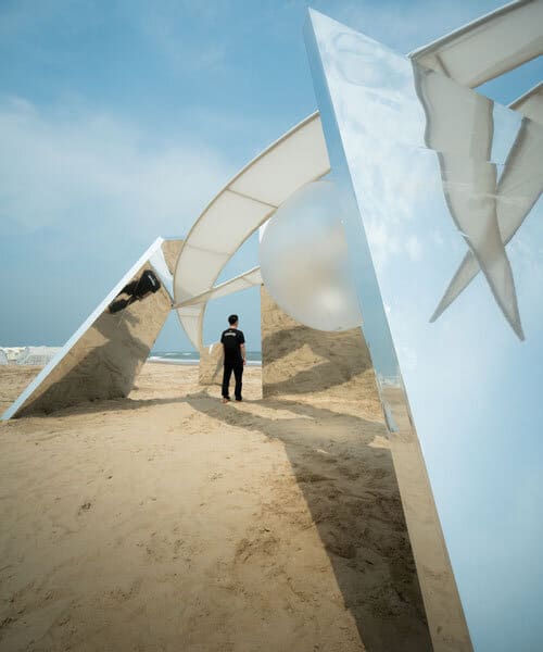 جناحان أبيضان يحيطان بكرة مضيئة معلقة فوق شاطئ رملي