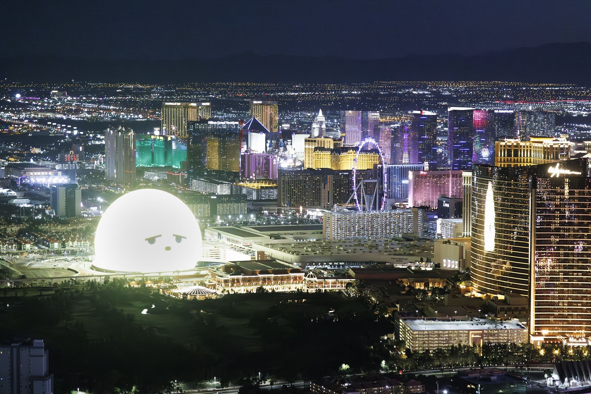 A night aerial view of the Las Vegas Strip glowing with vibrant lights across a flat urban landscape.