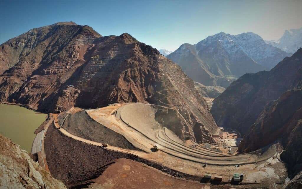 Wide view of the Rogun Dam under construction between the mountains in Tajikistan