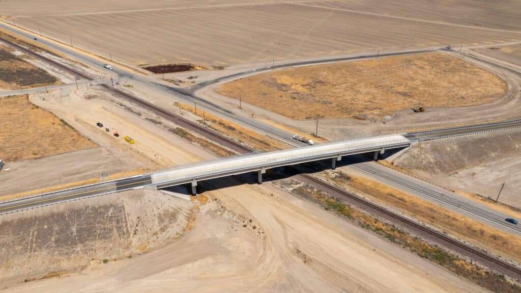 Aerial drone view showing the newly completed Avenue 88 grade separation with the overpass spanning existing railroad and roadway.