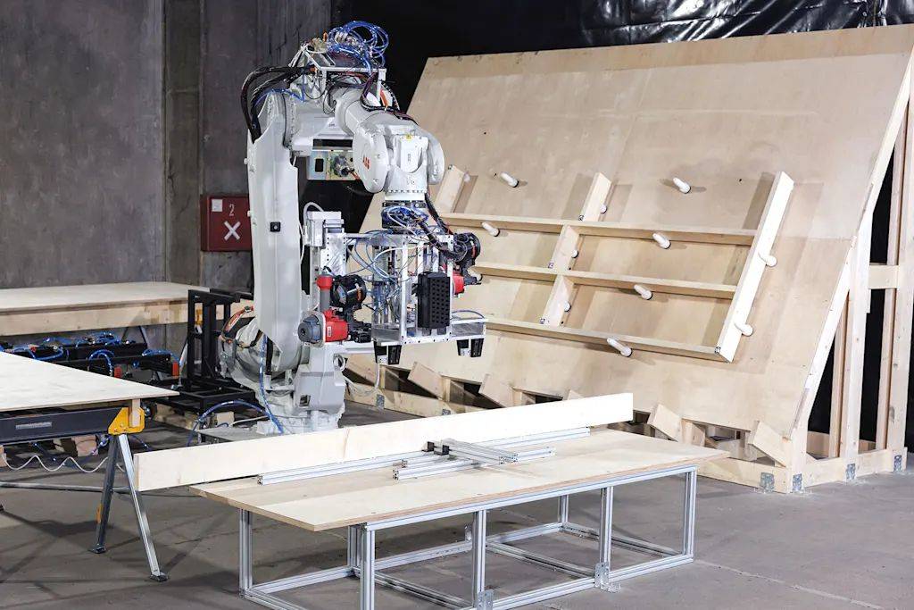 ABB robot manufacturing precise wall panels in a robotic micro-factory for housing reconstruction.