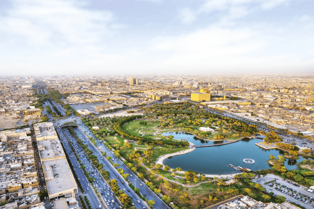 Aerial view showing the vast green areas of Al-Urubah Park in Riyadh, integrating walking trails and water features.