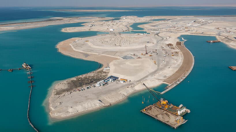 Aerial view of Shura Island on the Red Sea showing building clusters and waterfront pathways during construction.