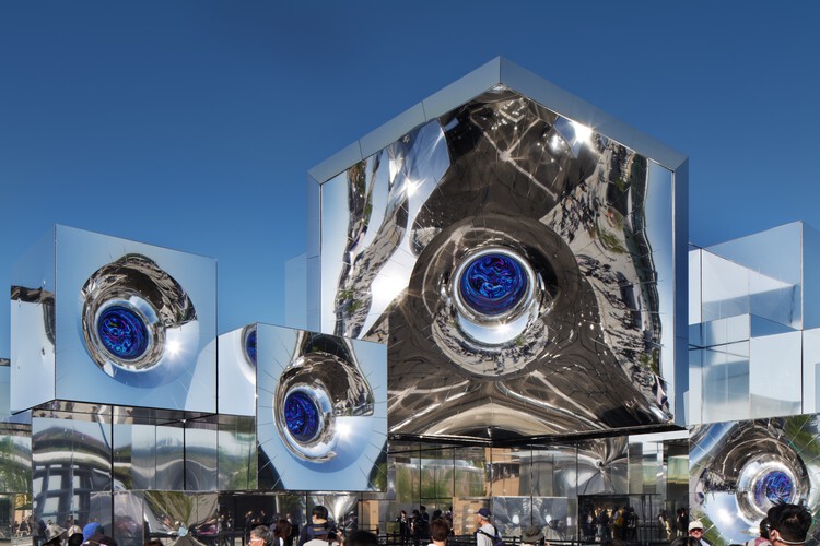 Mirrored fa&ccedil;ade of the Null&sup2; Pavilion at Expo 2025 Osaka reflecting the sky and urban surroundings