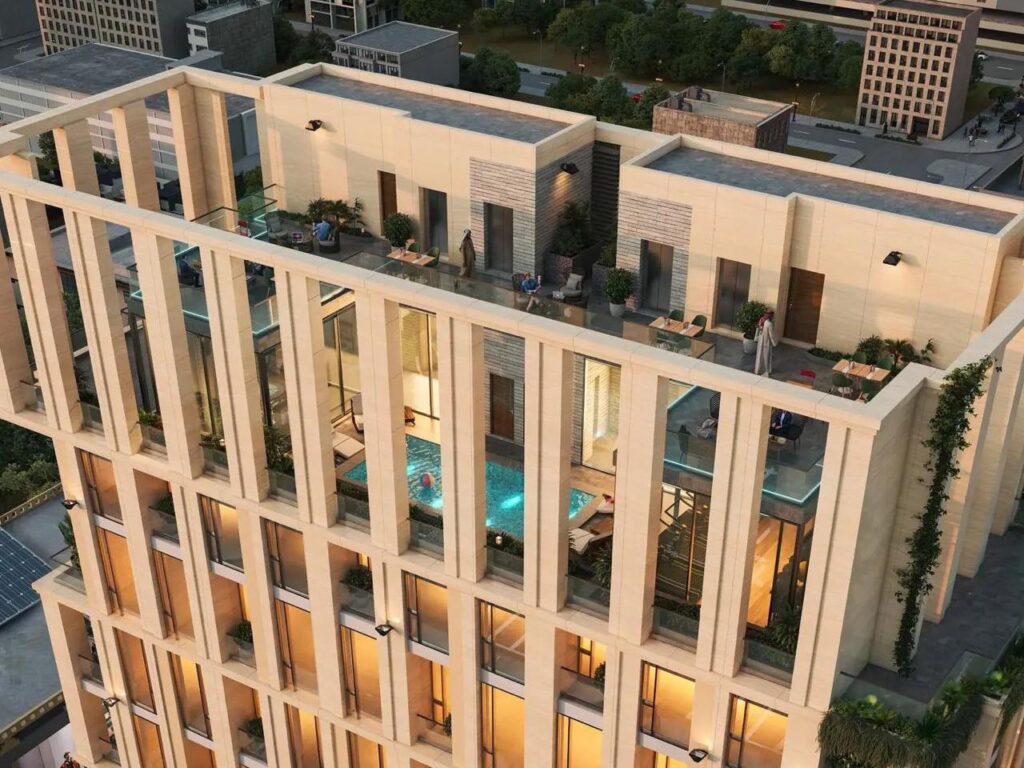 منظر جوي لمشروع &ldquo;The Rise&rdquo; يُظهر شرفة السطح المُجهزة بمسبح خاص، وأريكة راحة، ومنطقة جلوس مفتوحة مع إضاءة دافئة، وسط تصميم معماري عصري يمزج بين الخشب والزجاج والنباتات.