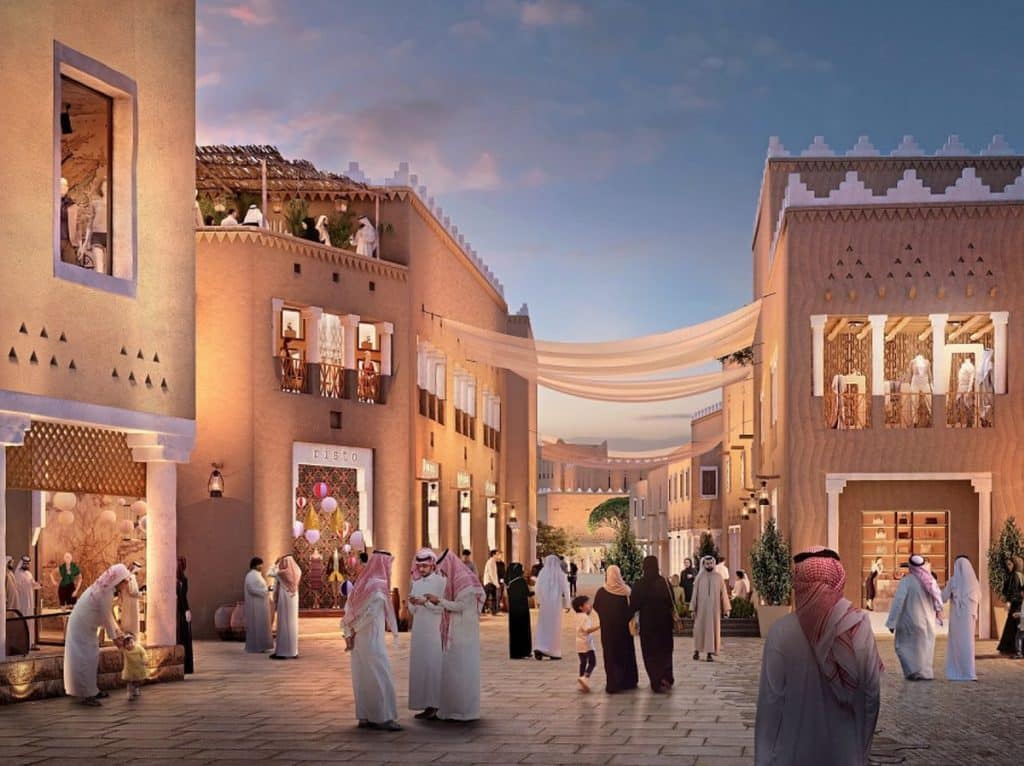 A vibrant street scene at Al-Zallal in Diriyah, featuring traditional Najdi architecture with people in local attire walking among shops and cafes under a soft twilight sky.