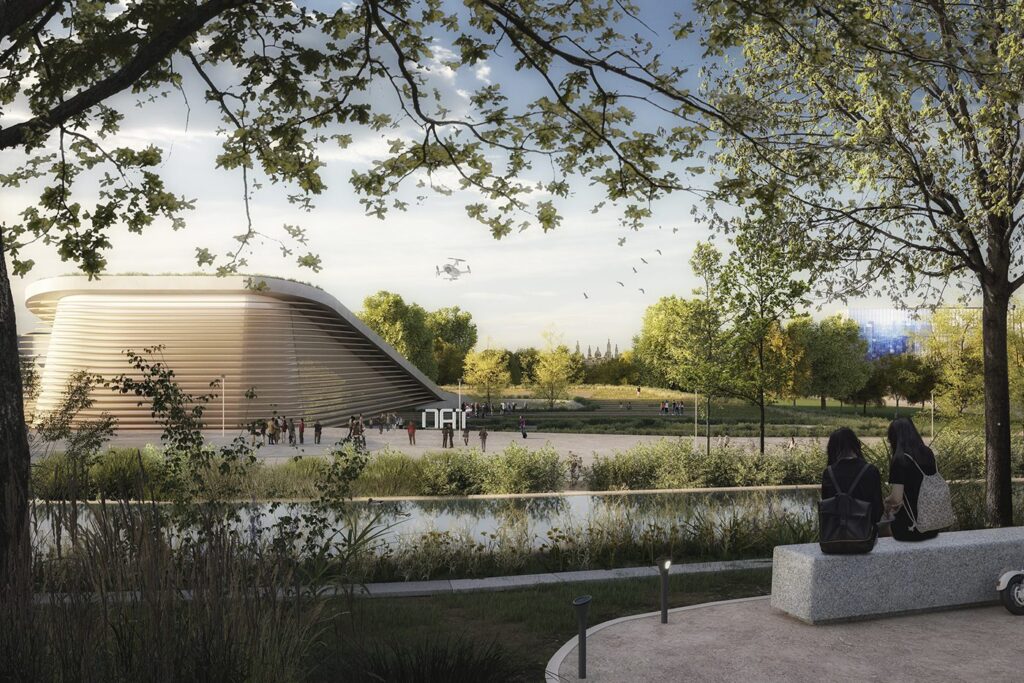 People relaxing by a pond near a futuristic building with trees and a drone flying overhead.