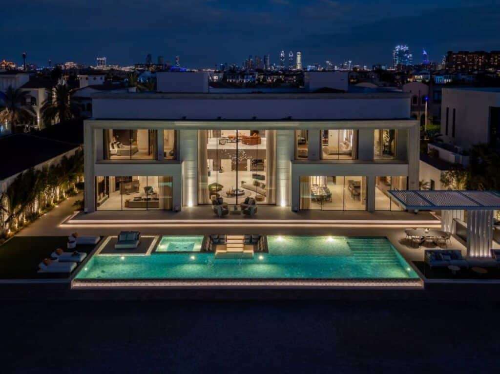 Night view of a villa with illuminated façade, pool, and Atlantis The Royal backdrop