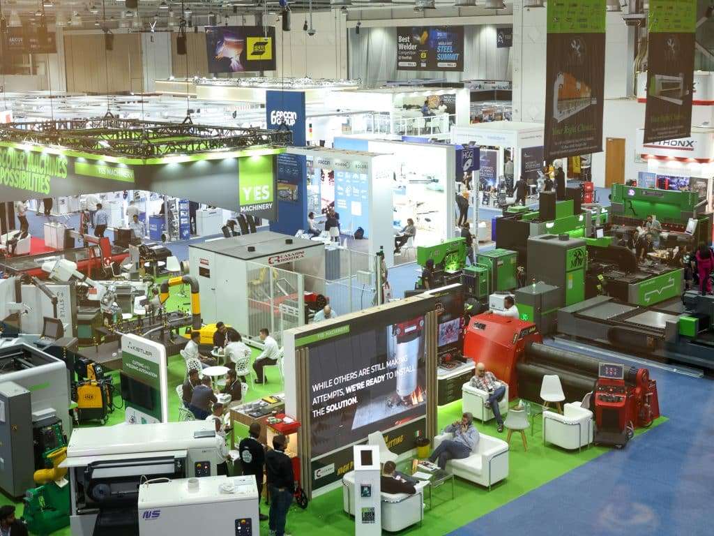 Visitors walking through exhibition booths and engaging with displays