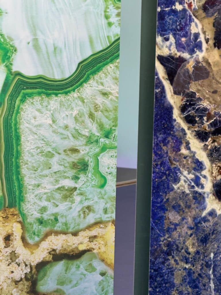 Natural stone slabs in green and blue tones with crystal-like textures on display at Cersaie 2025
