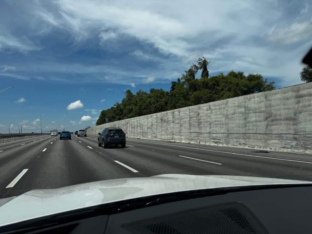 A long, monochromatic wall with varying heights lining a sidewalk in Miami.