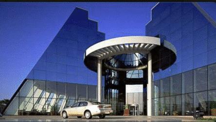 A beautiful example of the "plain and simple" aesthetic that defined commercial architecture in the 1990s. The design forgoes unnecessary ornamentation, focusing instead on clean lines, a large glass facade, and a functional layout that puts the product&mdash;the vehicle&mdash;at the center of the experience. It perfectly captures a moment when car showrooms were designed as serene, minimalist galleries.