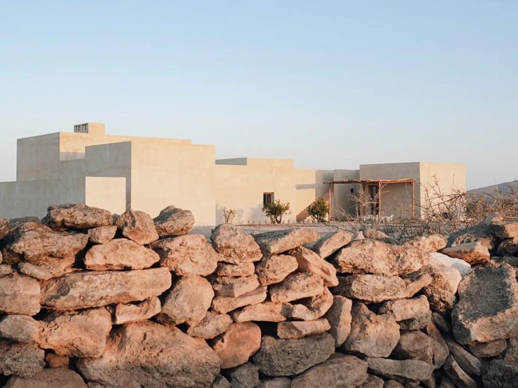 Exterior view of DDAR Villa surrounded by palm trees and Moroccan landscape