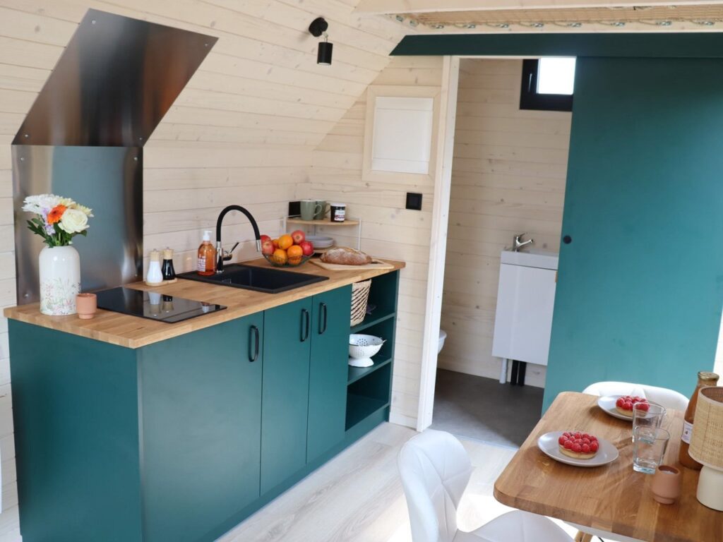 Compact kitchen in Nid Luxe with induction stove, hidden fridge, and organized cabinets