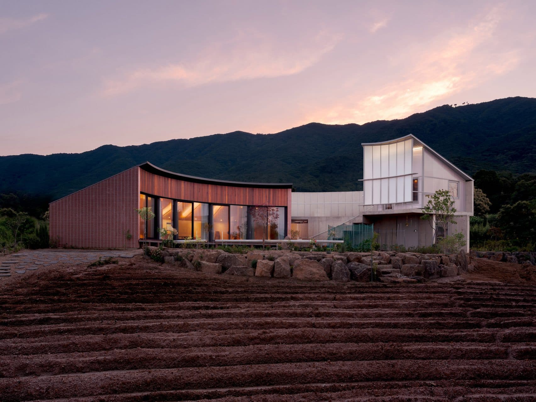 Pojeon House: A Curving Brick and Concrete Home Embracing a Central Garden