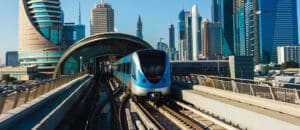 Dubai Metro train on the Red Line operating the new direct service, showing passenger flow on the platform during peak hours.
